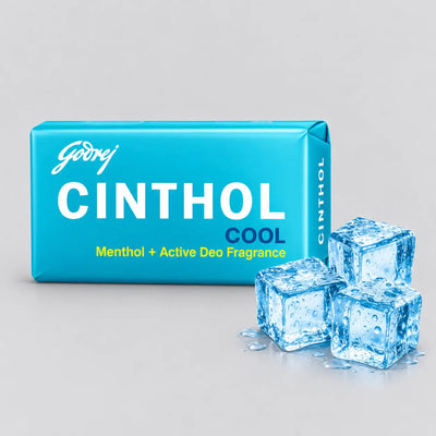 A bright blue box of Godrej Cinthol Cool deodorant fragrance with three clear ice cubes on a light gray background.