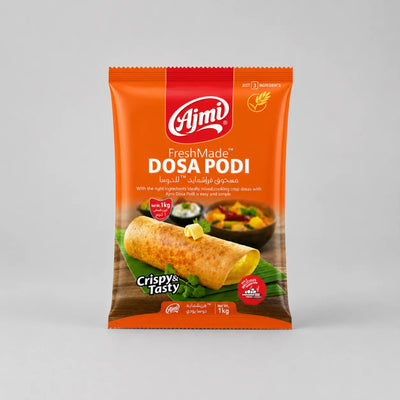 A 1kg package of Ajmi FreshMade Dosa Podi, featuring an orange bag with a photo of a crispy dosa roll on a light gray background.