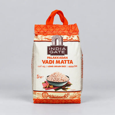 A 5 kg bag of India Gate Palakkadan Vadi Matta long grain rice, featuring a white bag with orange-red patterned borders, an illustration of the India Gate monument, and a bowl of prepared rice on the front, set against a neutral gray background.