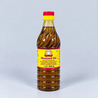 A 500 ml plastic bottle of mustard oil with a yellow and red label and a red cap, set against a light gray background.