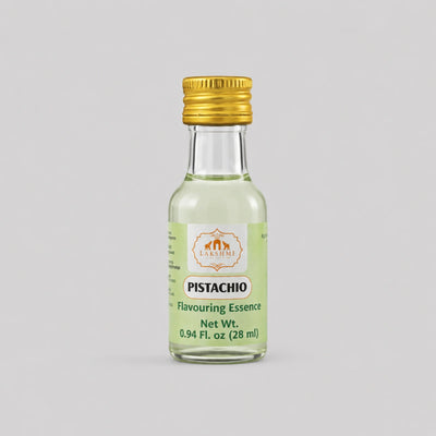 A small glass bottle of Pistachio Flavouring Essence with a gold cap and a light green label, centered on a solid gray background.