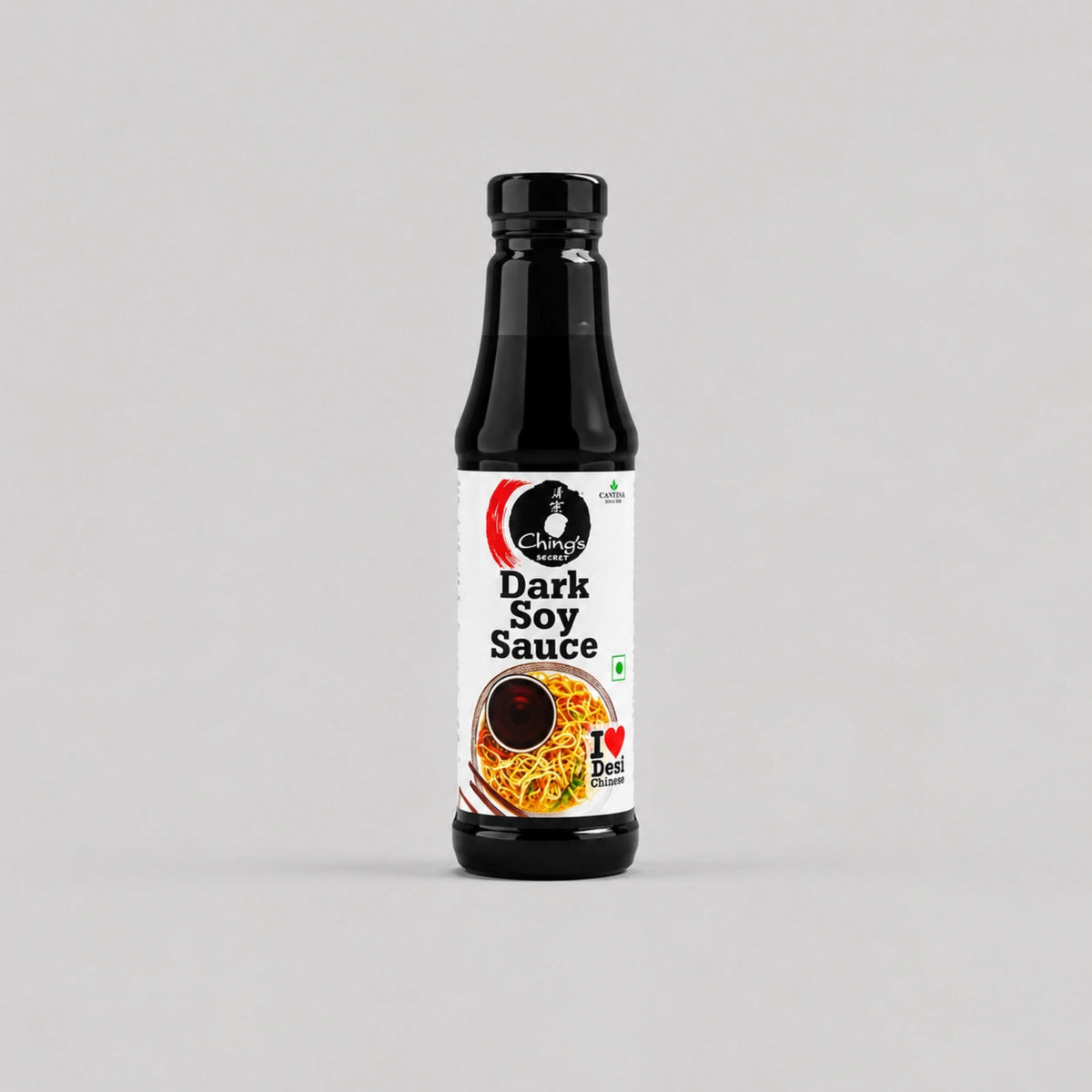 A bottle of Chettinad Dark Soy Sauce on a light gray background. The bottle is black with a white label featuring the Chettinad brand logo and an image of soy sauce noodles.