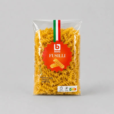 A clear plastic bag of Boni Fusilli rotini pasta, showing the yellow pasta inside, with a red circular logo and a green, white, and red Italian flag detail on the packaging, set against a neutral gray background.