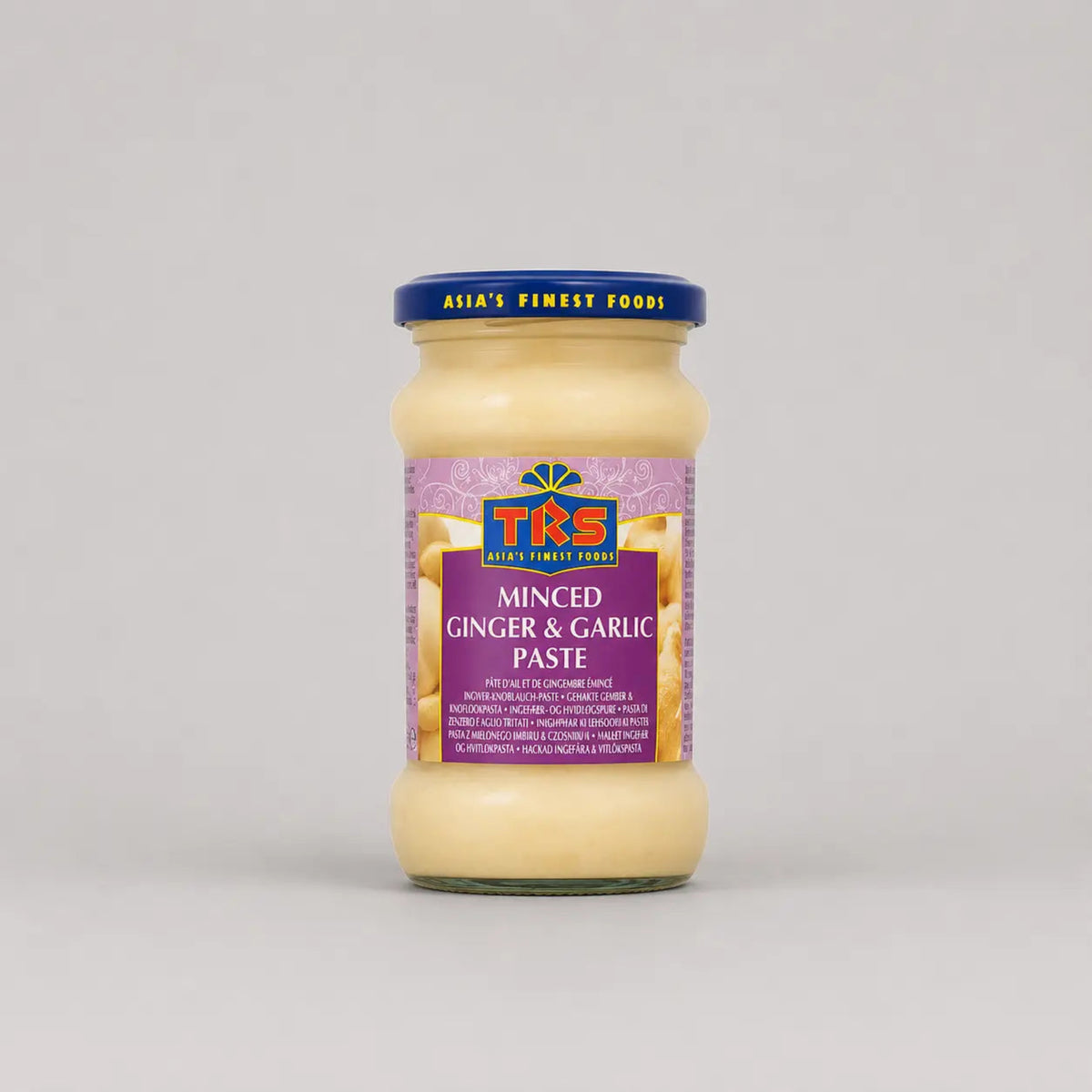 Jar of minced ginger and garlic paste with a purple label on a gray background