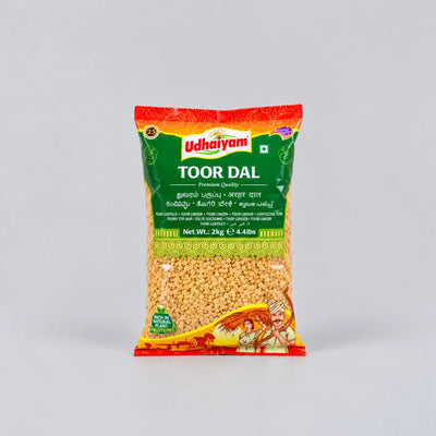 A 280g bag of Udhaiyam Toor Dal (Indian split lentil) on a light gray background. The packaging features a green and red label with the brand name 'Udhaiyam' in white, and a clear window showing the yellow-brown lentil inside.