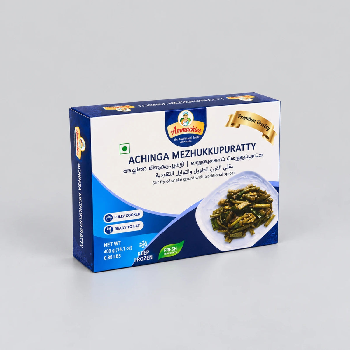 A box of Annamachi Achinga Mezhukkupuratty, a frozen Malay food product, displayed on a neutral light gray background. The packaging is primarily blue and white with a photo of the cooked green and yellow vegetable dish on the front.