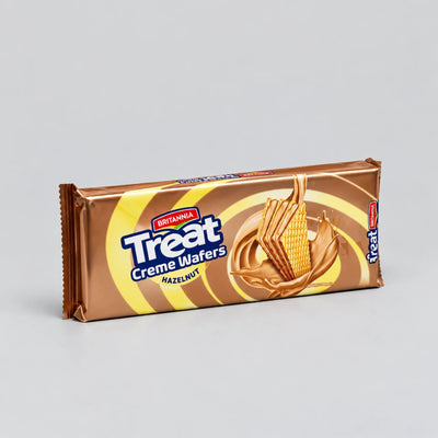 A single wrapped bar of Britainia Treat Creme Wafers (Hazelnut) on a neutral light gray background.