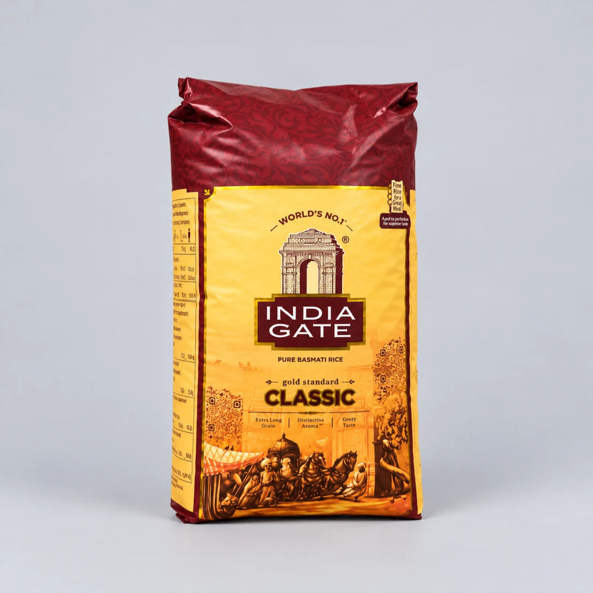 A bag of India Gate Classic Basmati Rice standing upright against a light gray studio background. The packaging features a golden yellow label with the India Gate brand logo and an illustration of horse-drawn carriages, topped with a dark red crimped seal.