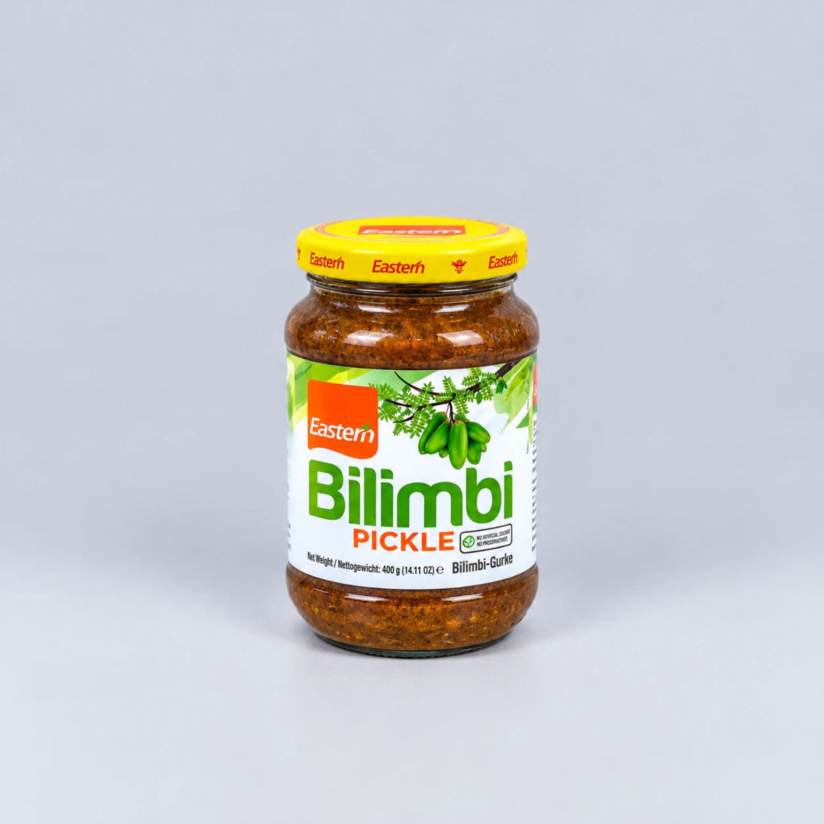 A glass jar of Eastern Bilimbi Pickle with a yellow lid and a white label featuring green and orange branding, set against a plain light gray background.