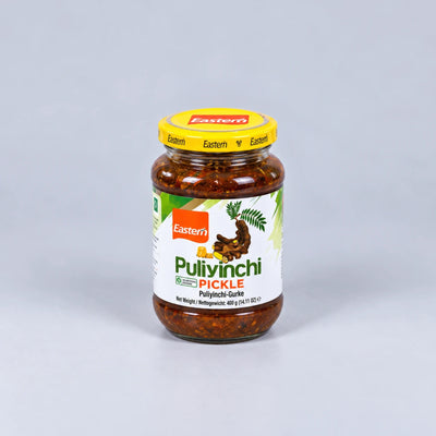 A glass jar of Eastern brand Pulivinchi Pickle with a yellow lid, set against a plain light gray background.