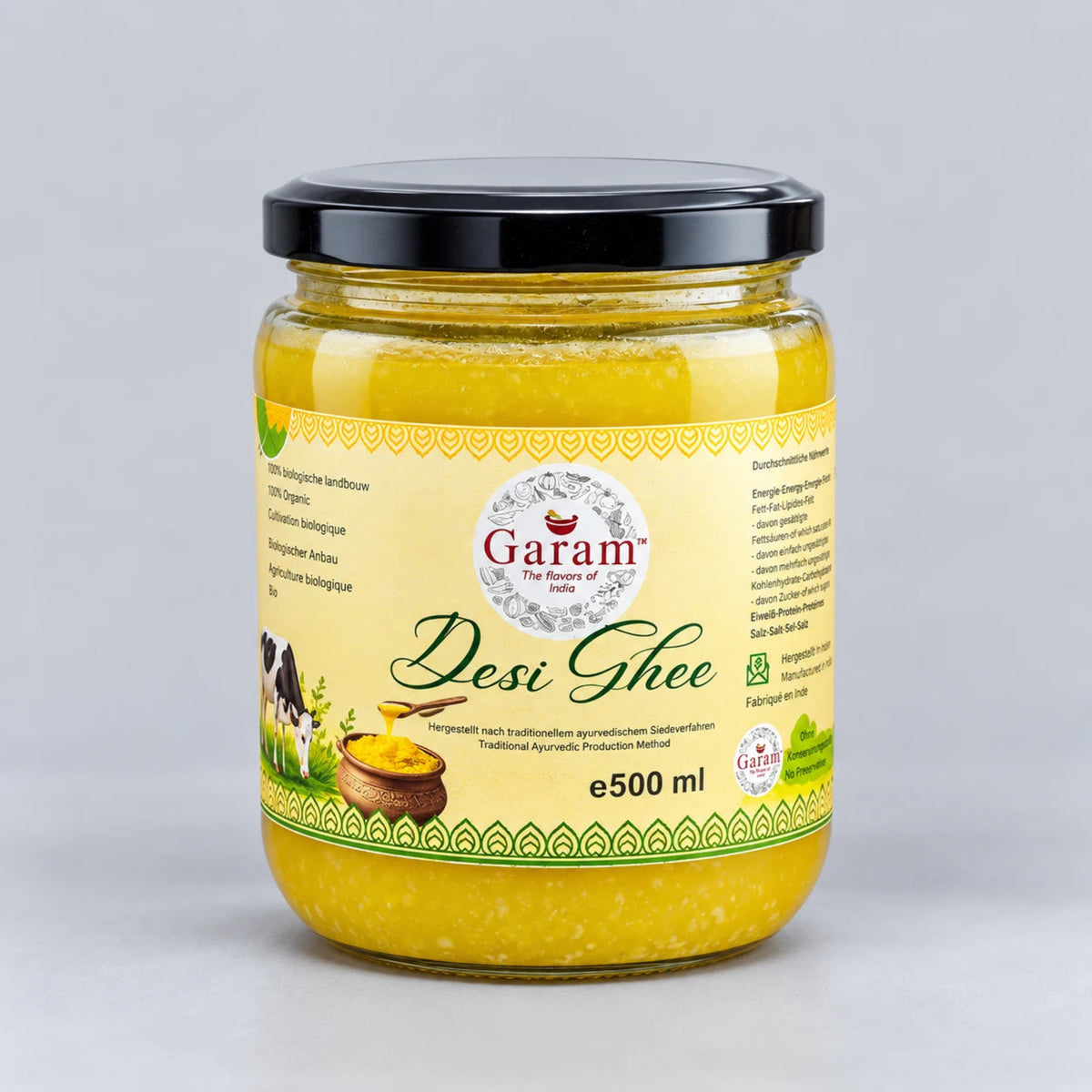 A 500 ml glass jar of Garam Desi Ghee with a black lid and a cream-colored label, set against a neutral light gray background.