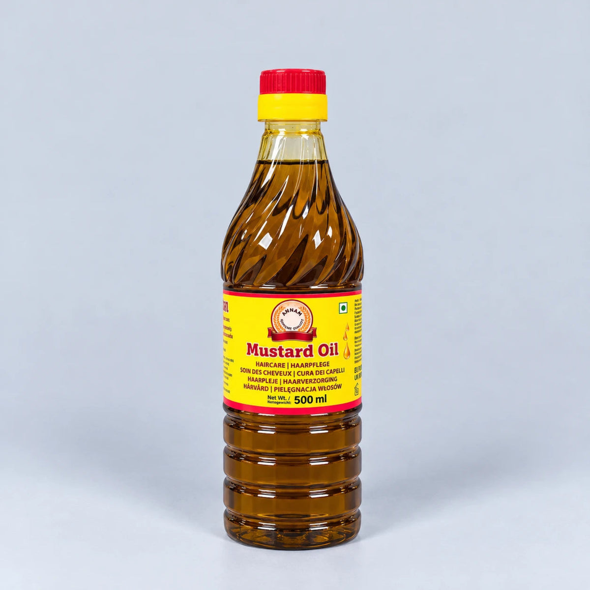 A 500 ml plastic bottle of mustard oil with a yellow and red label and a red cap, set against a light gray background.