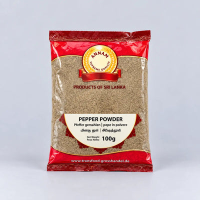 A 100g package of Annam Gourmet Pepper Powder, featuring a red and beige packaging design with a clear window showing the brownish-beige ground pepper inside, set against a light gray background.
