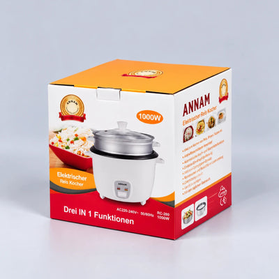 A boxed electric rice cooker shown on a clean light gray studio background. The package is predominantly orange, white, and red, with a printed photo of the rice cooker on the front and the brand name ANNAM visible on the side panel.