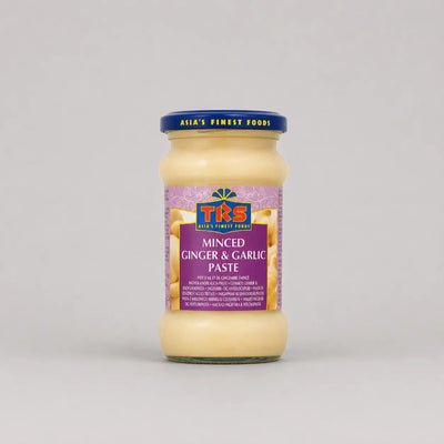 Jar of minced ginger and garlic paste with a purple label on a gray background