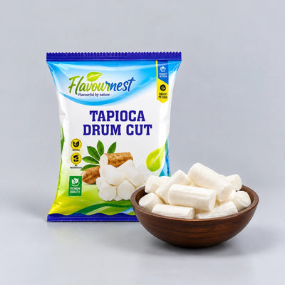 A bag of Flavournest Tapioca Drum Cut snack stands next to a small wooden bowl filled with pale white drum-shaped tapioca pieces on a light gray studio background.